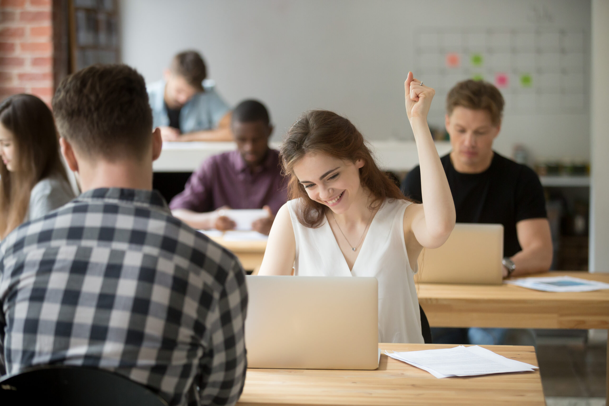 Happy female worker gesturing Yes satisfied with good news on stock market and company business success while working in coworking space. Student excited with high evaluating grade. Reward, recompense